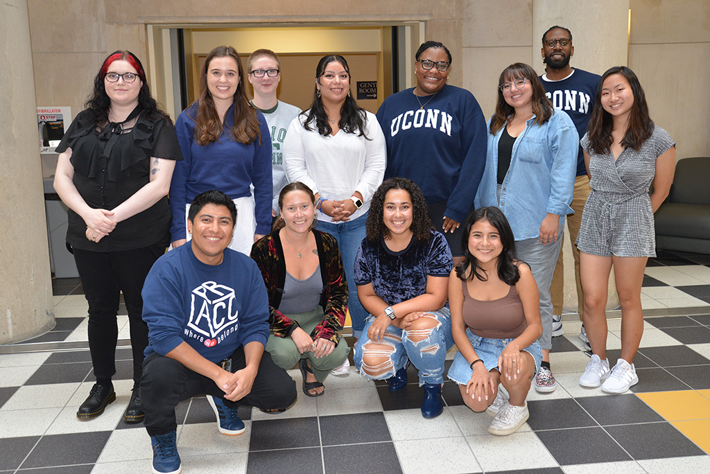 The twelve members of the Higher Education master's program's Class of 2024 pose for a photo in the Gentry Building.